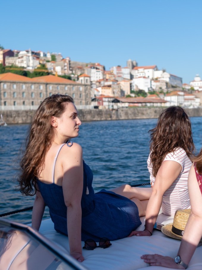 a woman sitting on a dock next to a body of water