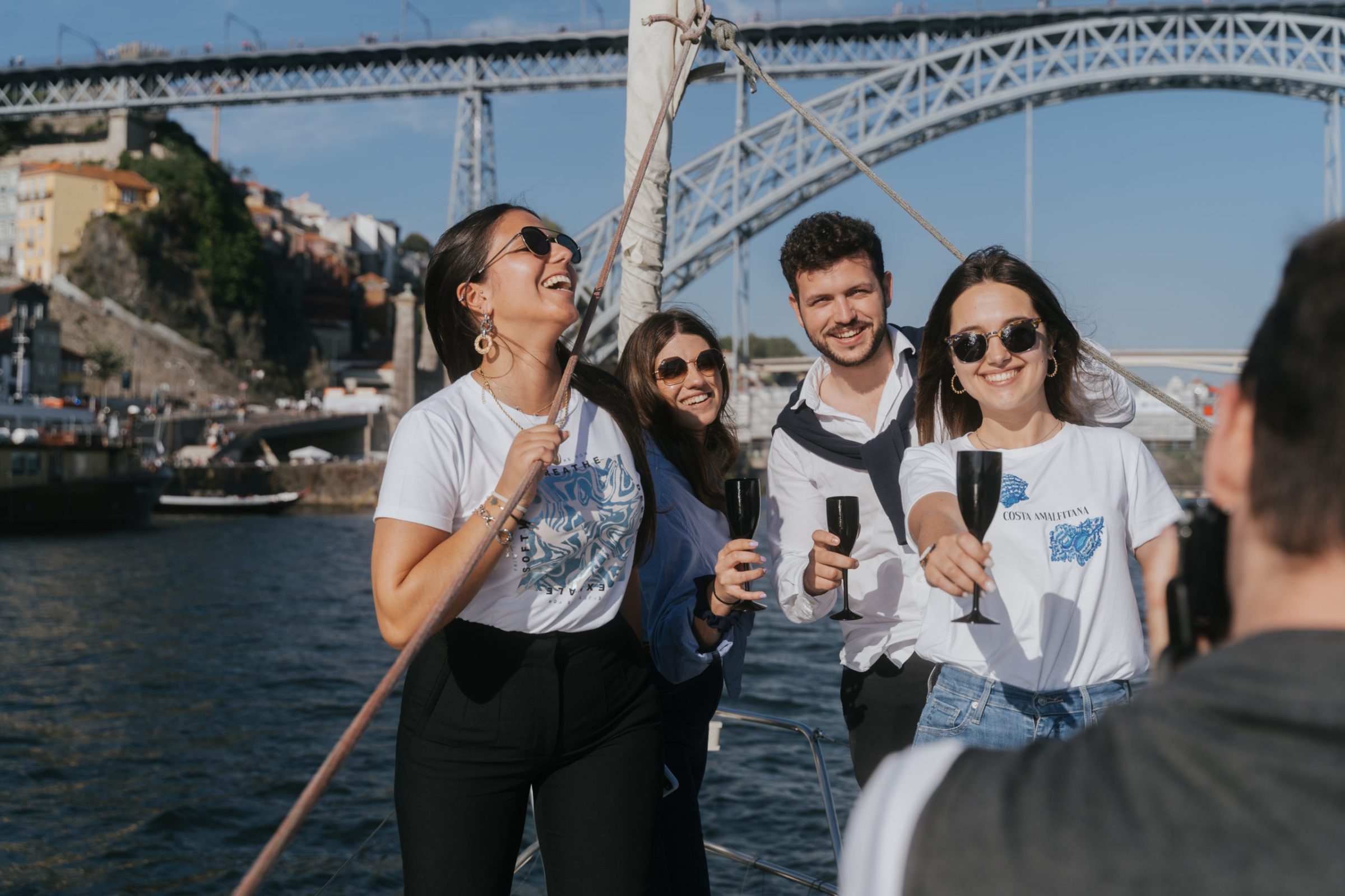a group of people standing on a bridge over a body of water rio douro sailing 360
