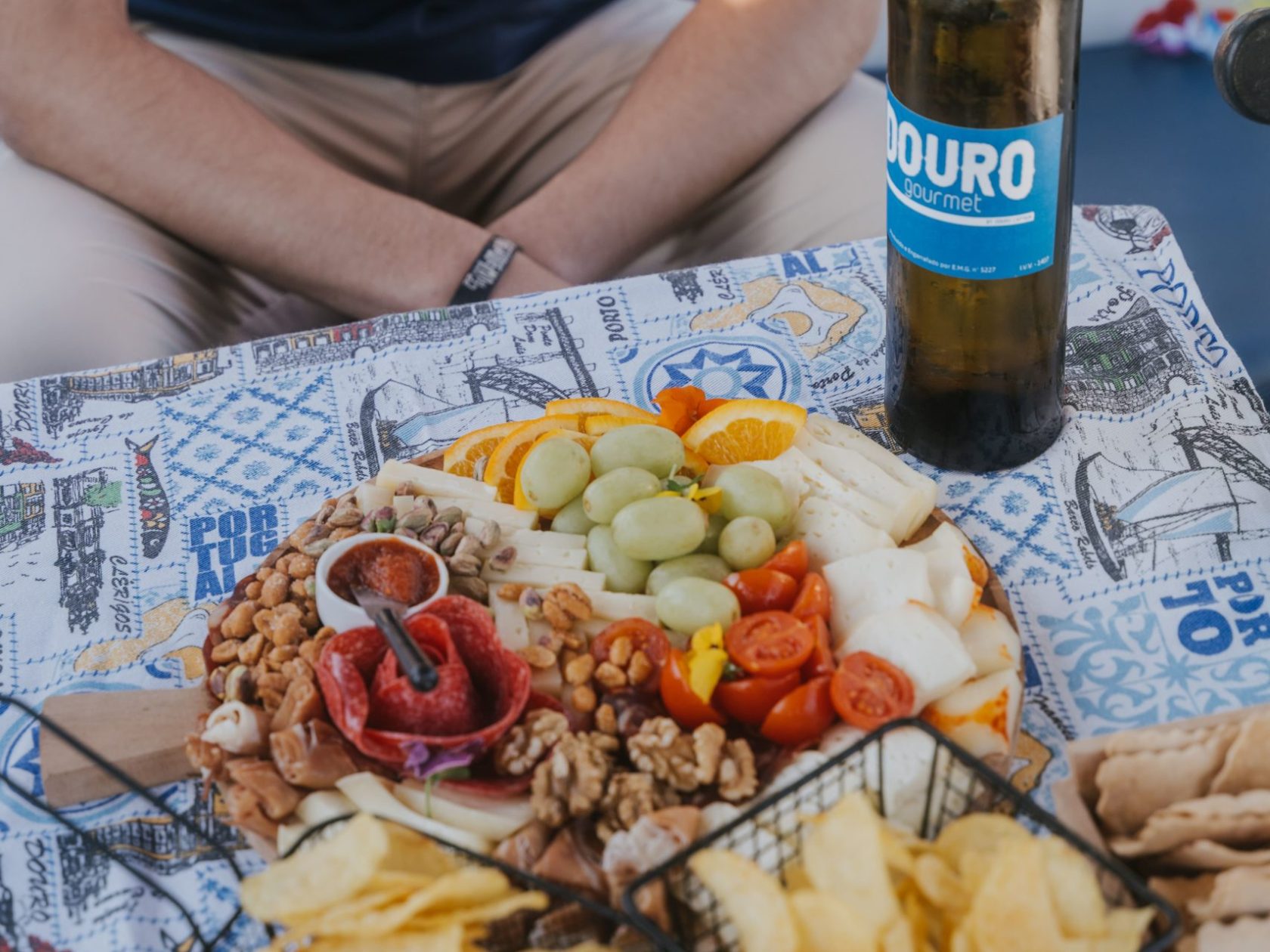 a person sitting at a table with food and a bottle