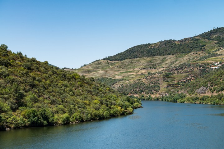 River winding through lush green hills under a clear blue sky.