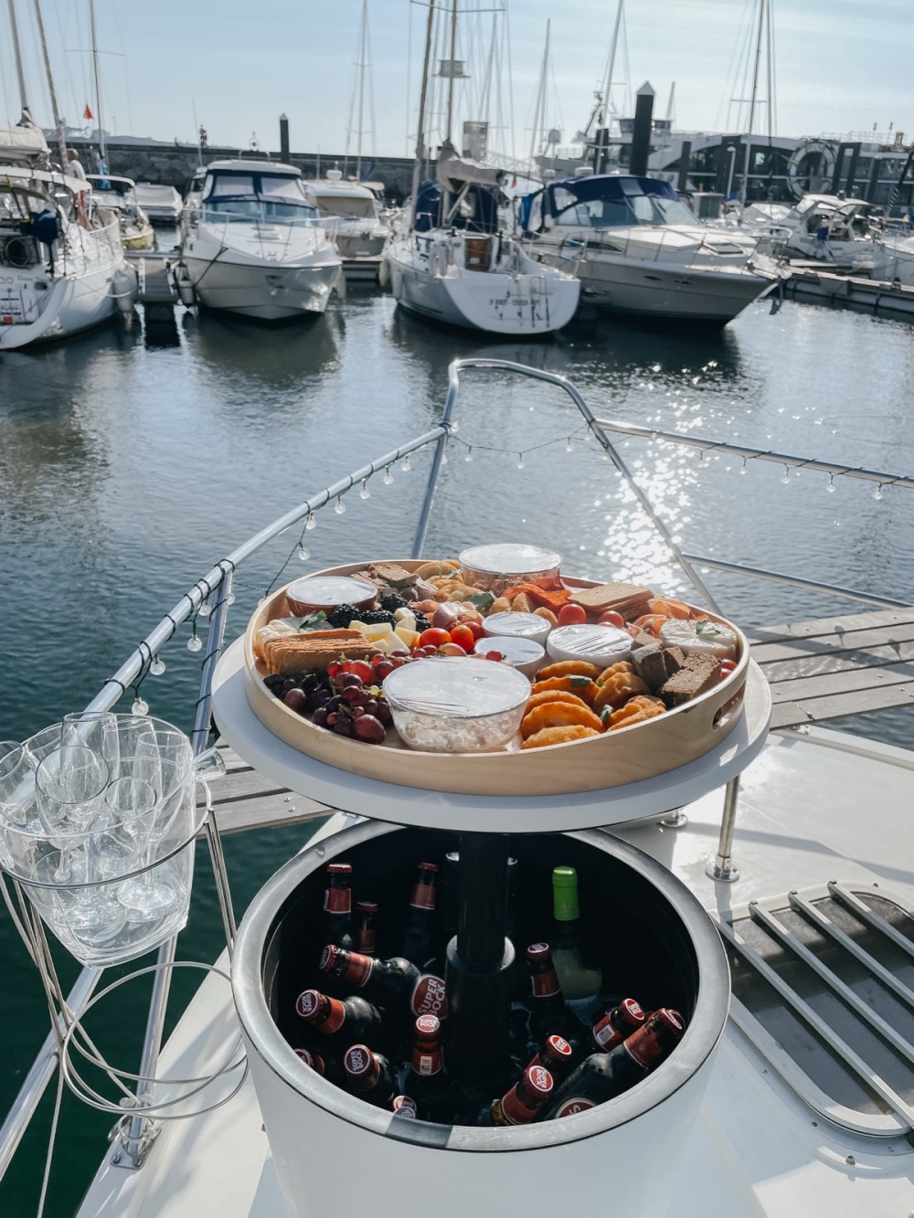 A board of regional snacks and bottles of wine chilling on a boat on the river in Porto