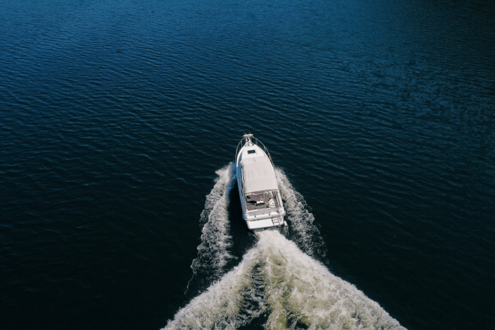 Aerial view of a motorboat leaving a wake on a large body of water.